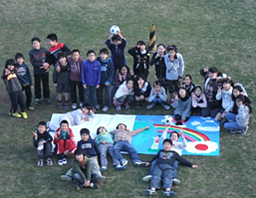 写真: コンセプトから作成した壁画を囲む白幡小学校の児童たち