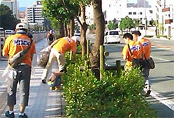 写真: 街路樹を清掃する社員