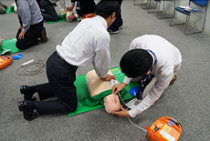 写真: AEDを操作する社員