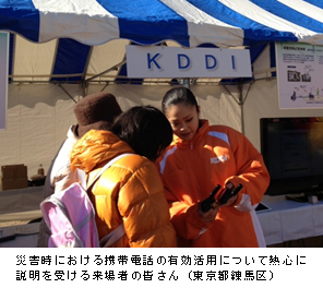写真: 災害時における携帯電話の有効活用について熱心に説明を受ける来場者の皆さん (東京都練馬区)