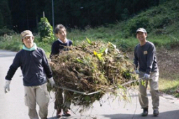 写真: 堆肥にする草を運ぶ社員