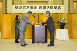 写真: 石原東京都知事 (左) から商品開発統括部本部 商品品質管理部長 中村 公彦 (右) に感謝状を授与 (東京都庁内)