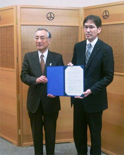 写真: 東京都千代田区と協定を結ぶ総務・人事本部総務部長土橋明 (右)