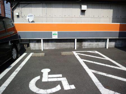 写真: 「ゆずりあい駐車場マーク」のステッカーの設置したauショップ静岡小黒店の駐車場