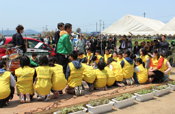 写真: オープニングセレモニーで挨拶する「一般社団法人福島復興ソーラー・アグリ体験交流の会」代表半谷栄寿氏 (写真中央) と地元の小学生