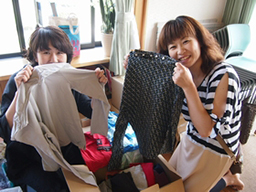 写真: KDDI北海道支社から届いた材料のTシャツを受け取る編み手の皆さん