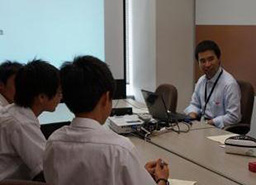 写真: 中学生からの質問に答えるKDDI CSR・環境推進室 鳥光健太郎