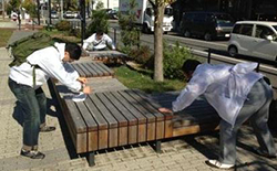 写真: ベンチの水拭き作業の様子
