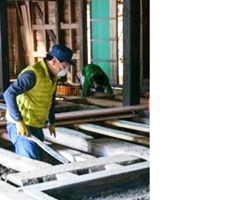 写真: 老朽化した床材の撤去作業