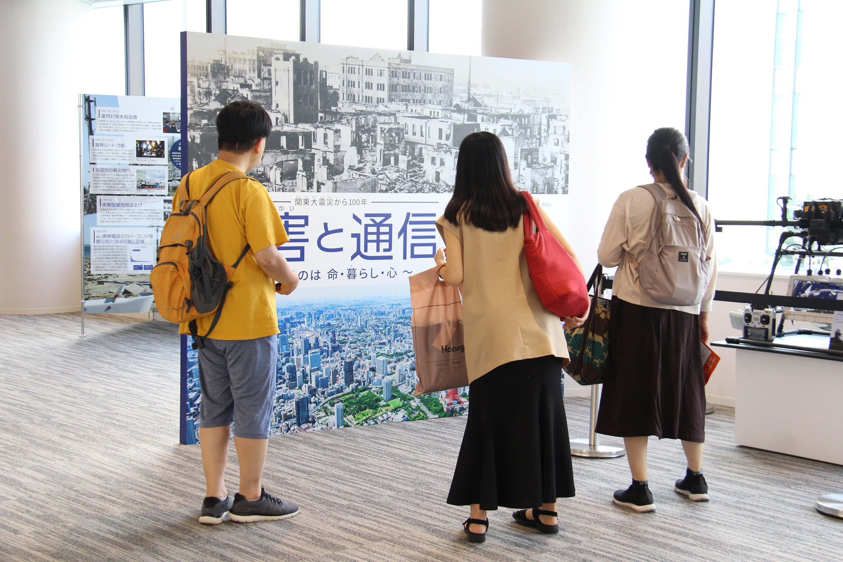 関東大震災当時と現在の街並みを比べたパネルに見入る来館者の皆さん。